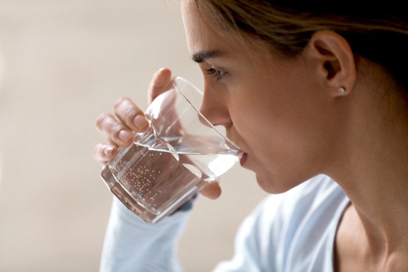 femeie care bea apa dintr-un pahar