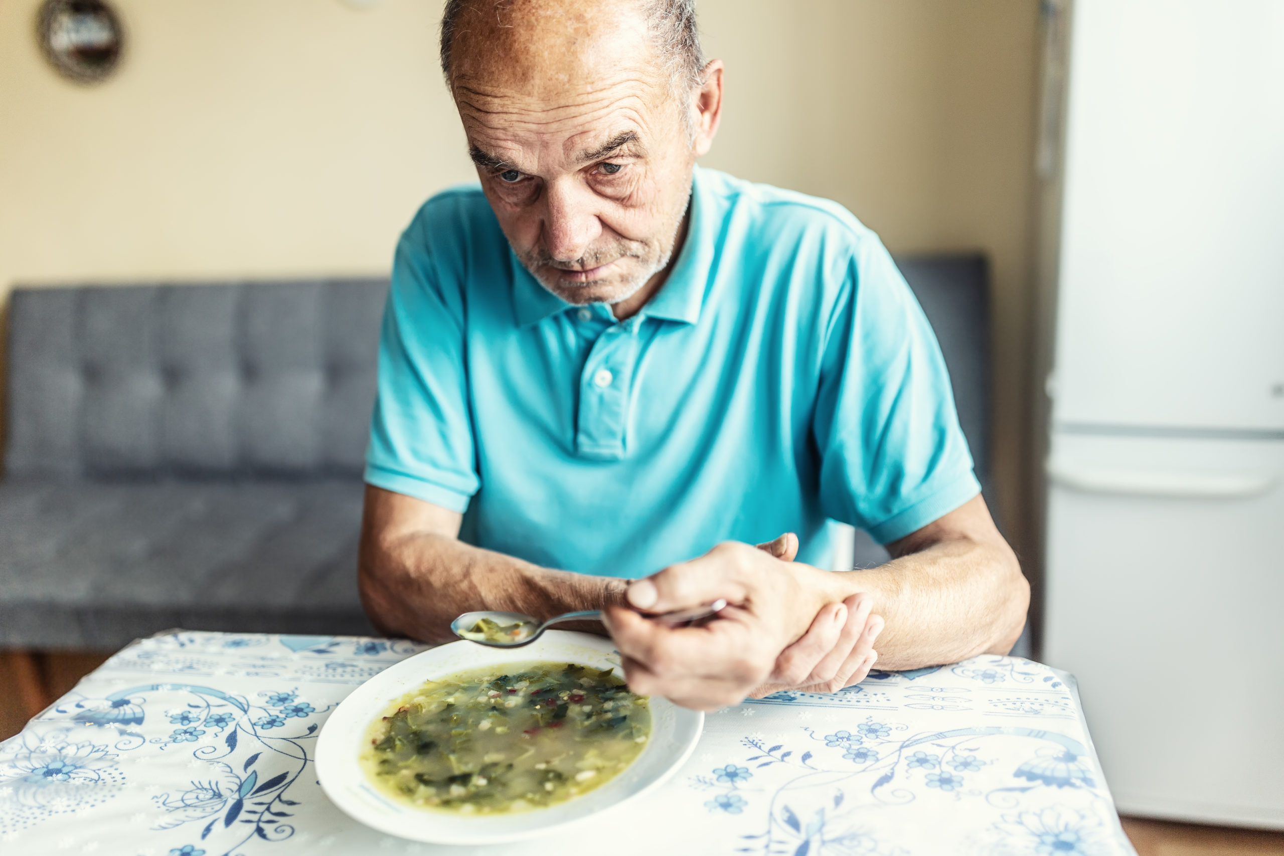 persoana in varsta care se chinuie sa manance