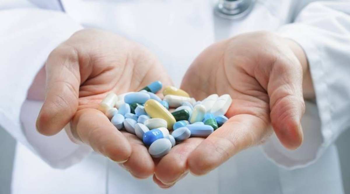 mainile unui doctor ce tin medicamente pe palme