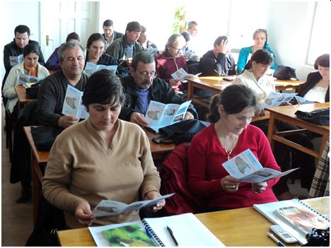 persoane care stau intr-o sala de curs si citesc