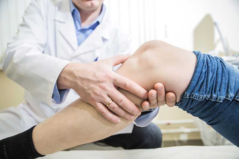 doctor consulta genunchiul pacientului