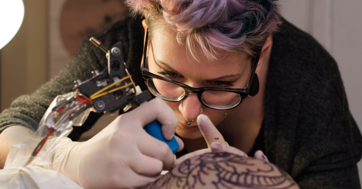 persoana care lucreaza un tatuaj
