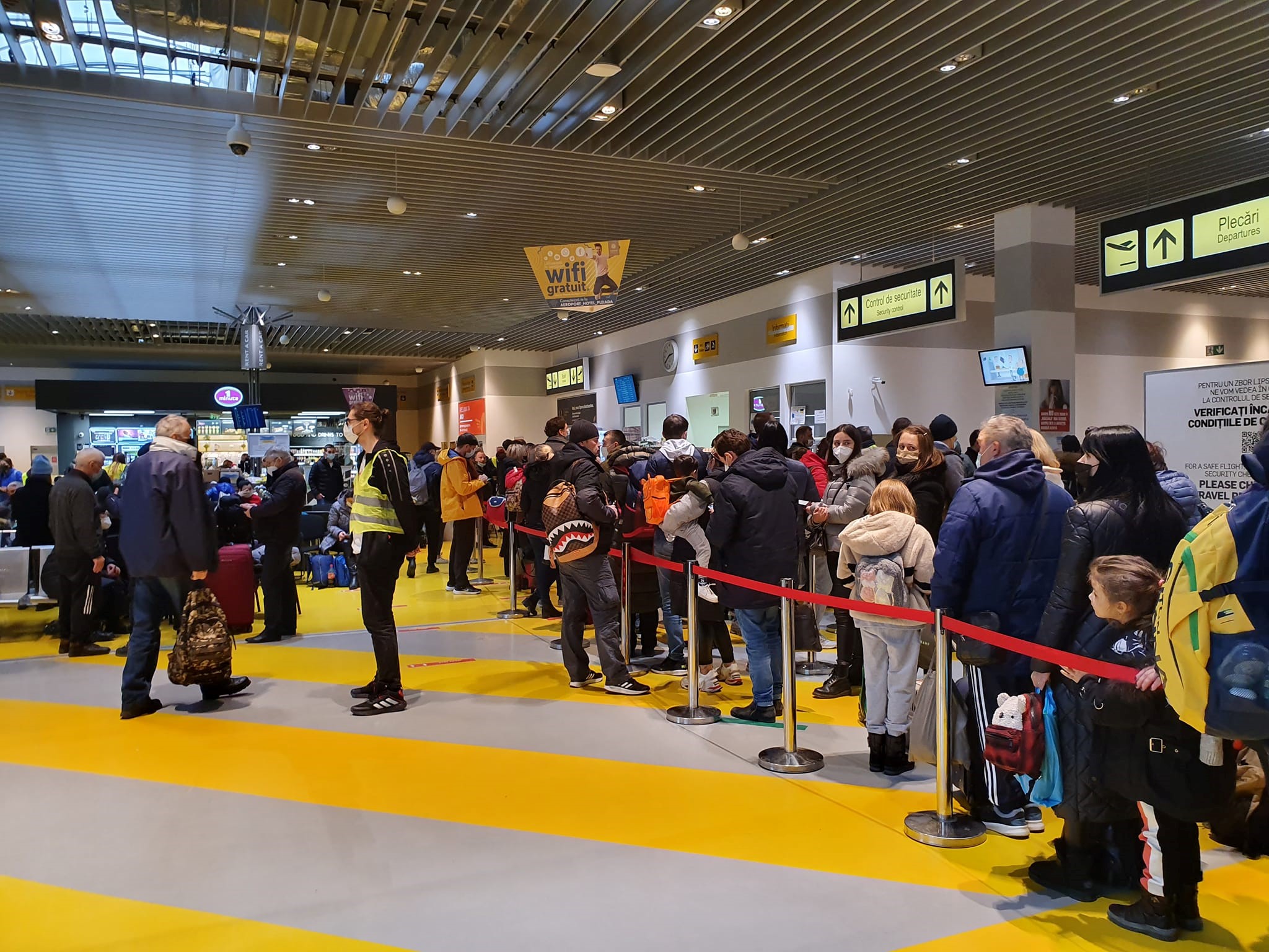 mai multi oameni care stau la coada la aeroport