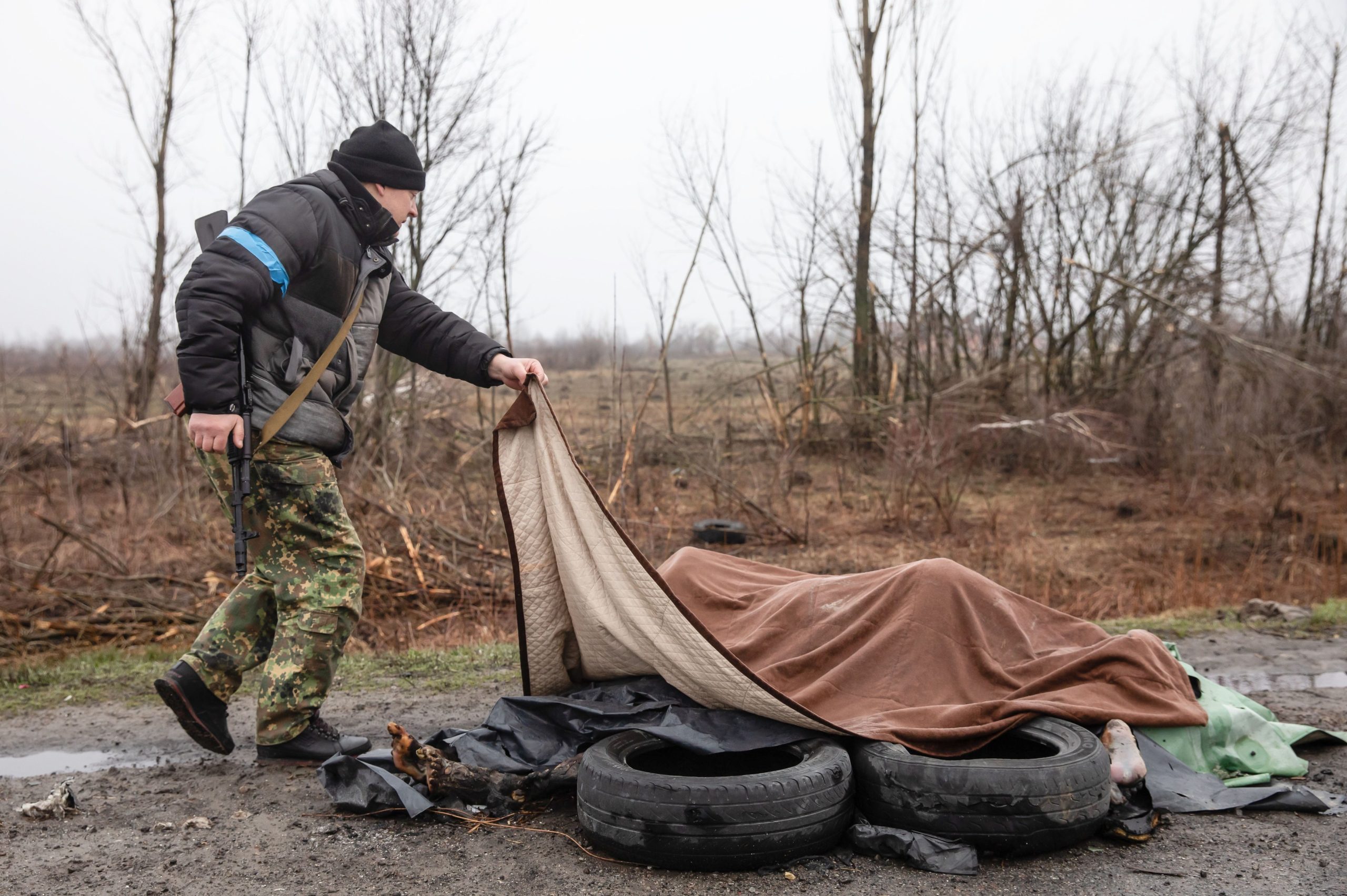 crimele asupra civililor din Bucea, barbat ce acopera trupurile ucrainenilor morti in urma atacurilor din Bucea