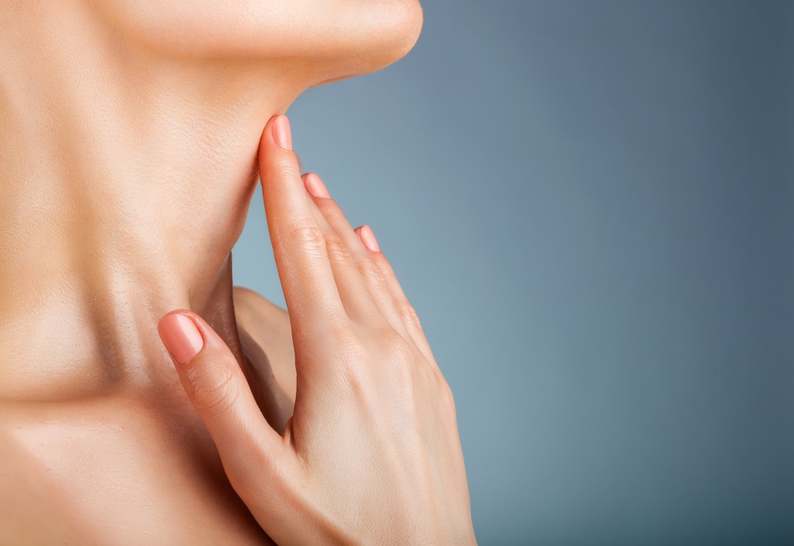 femeie care pune mana pe gat din cauza nodulilor tirodieni
