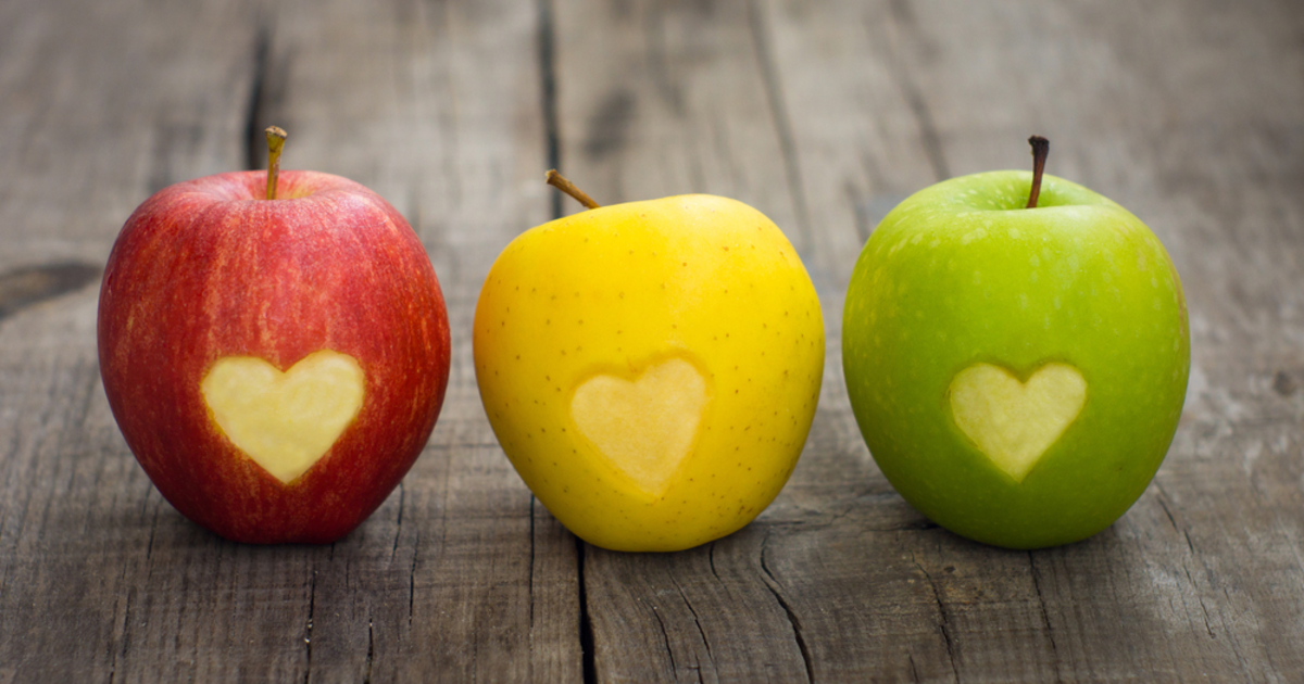 trei mere de diferite culori cu o inima pe centru