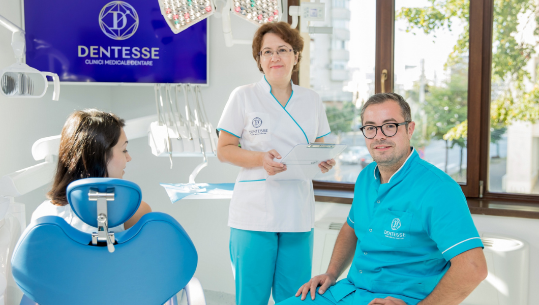  o imagine cu doi medici dentisti si un pacient in cadrul clinicii dentesse