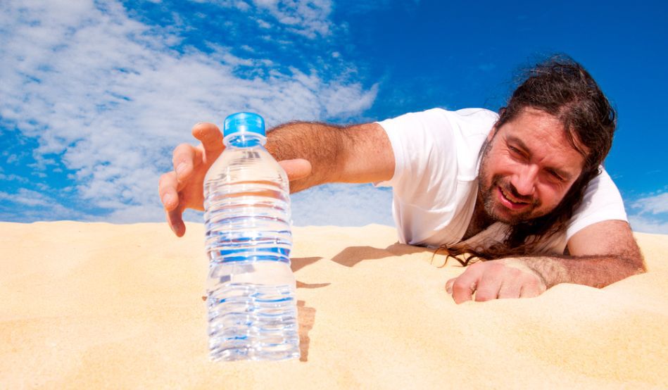 un bărbat și o sticlă de apă în deșert