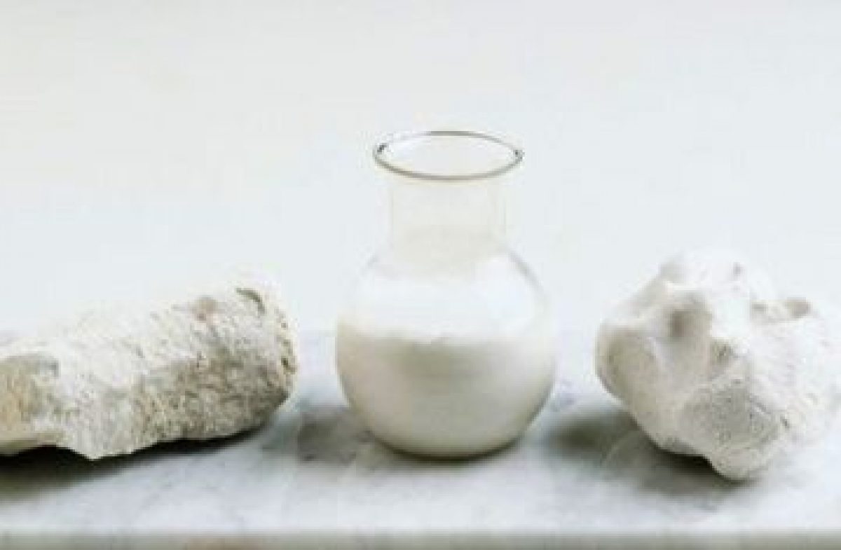 carbonat de calciu in forma de roca si in forma lichida intr-un vas pe o masa