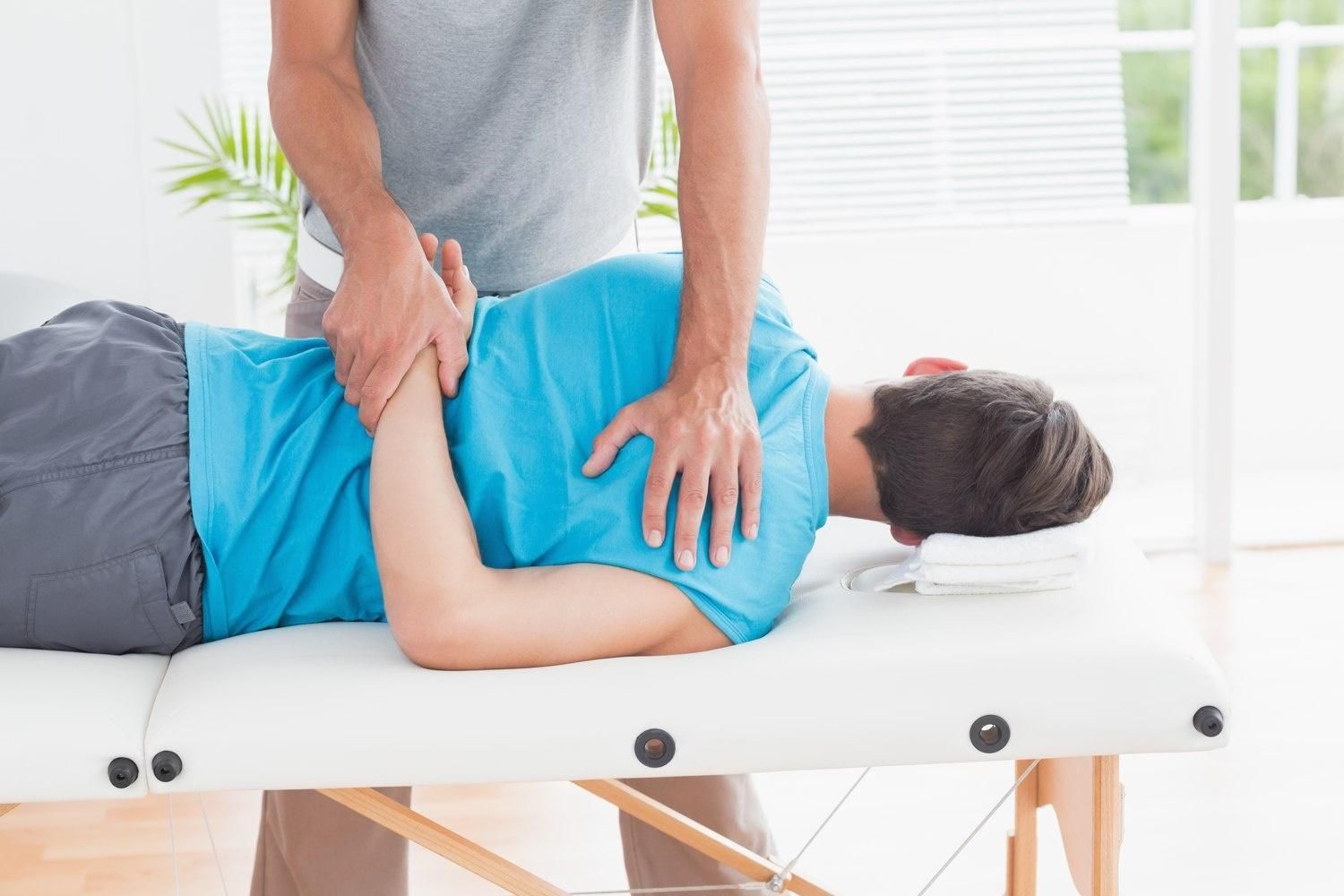 kinetoterapeut aplica masaj unui pacient