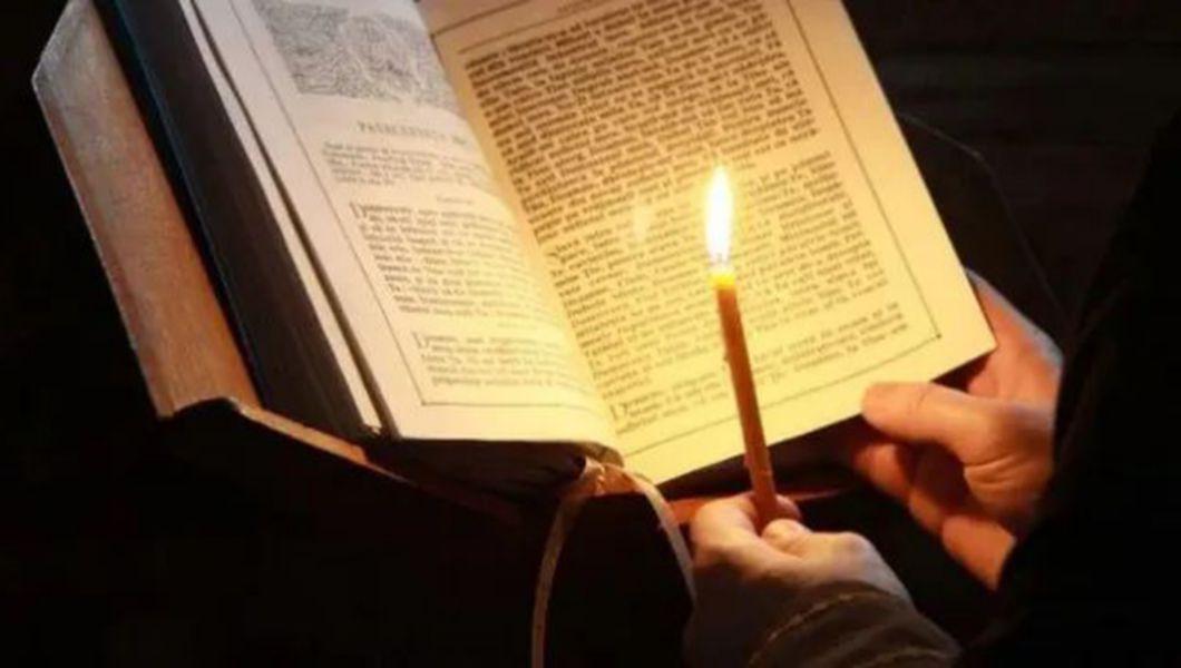 o carte de rugăciuni și o lumânare aprinsă