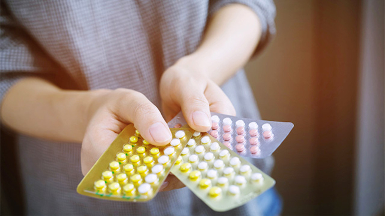 femeie care tine mai multe blistere cu pastile contraceptive in mana