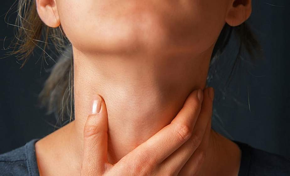 femeie care se tine de gat din cauza problemelor cu tiroida