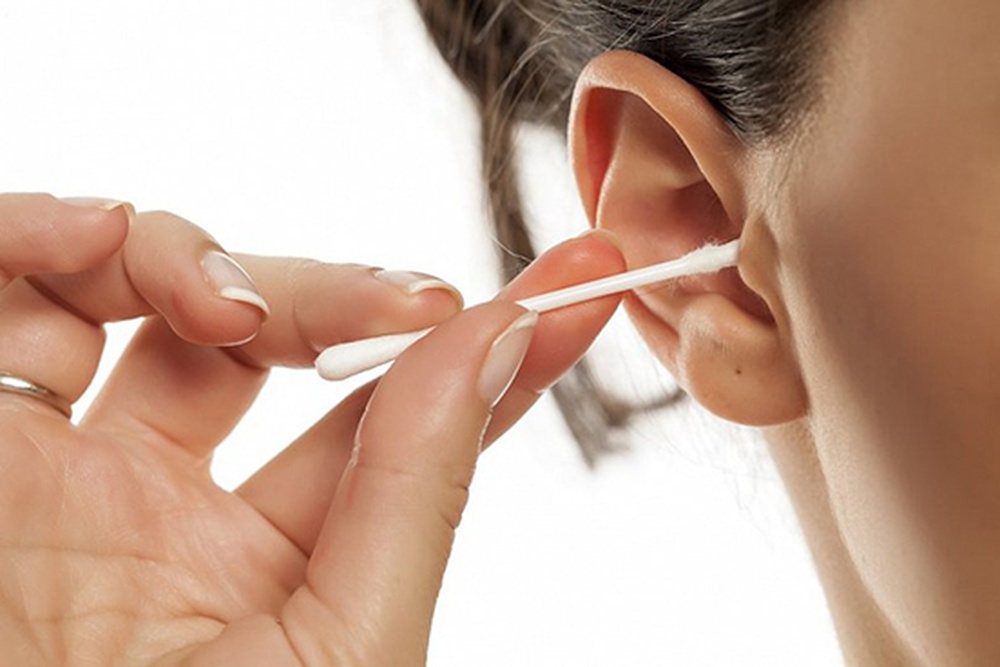 femeie care isi curata urechile folosind un betisor