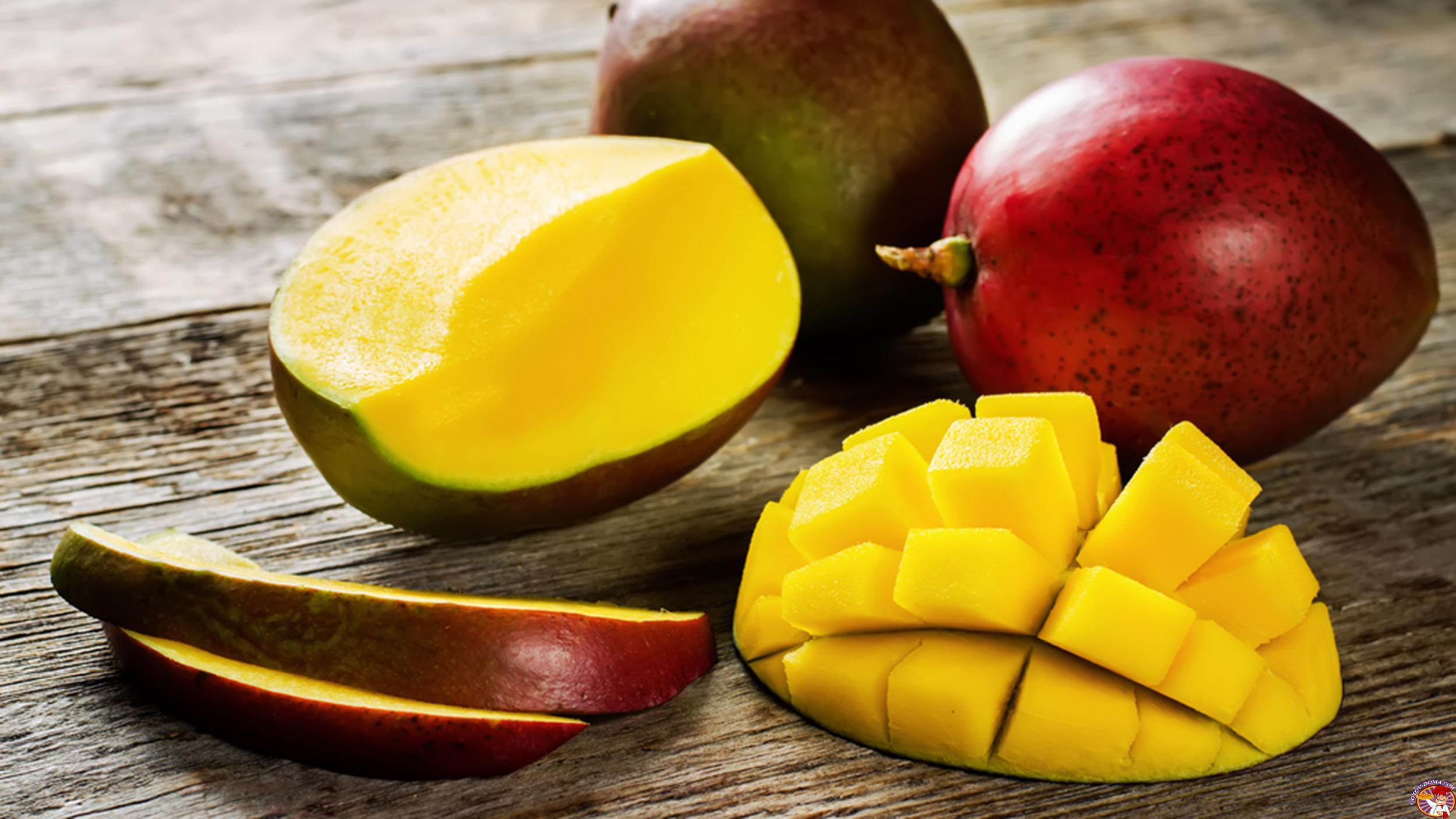 mango taiat si fructe intregi pe o masa