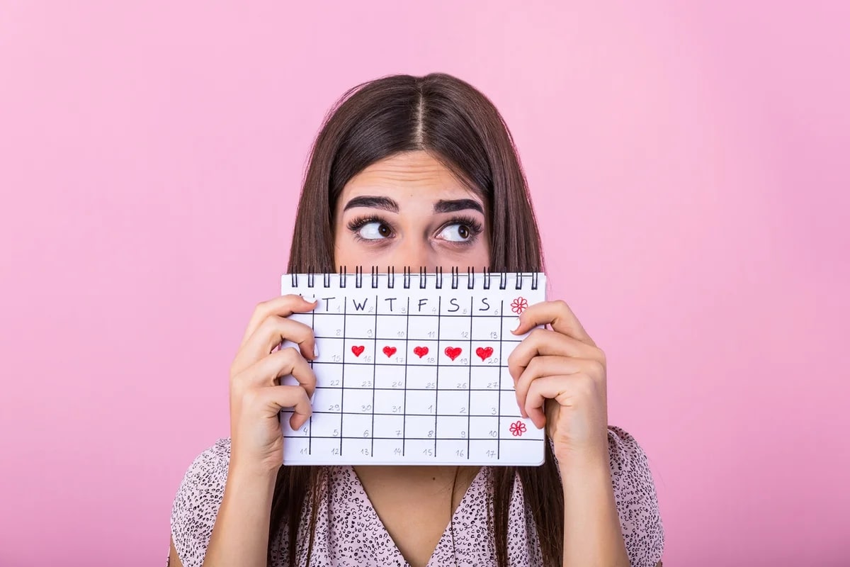 femeie care tine un calendar in mana